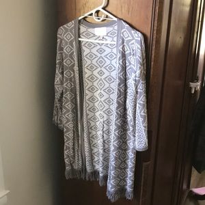 Skies are Blue grey and white open cardigan with fringe edging on bottom. Size M